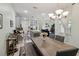Open-concept dining area features a modern chandelier, neutral walls and access to the kitchen and living area at 9743 Amber Chestnut Way, Winter Garden, FL 34787