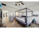 A spacious carpeted main bedroom with a dark four-poster bed and a vanity area at 9743 Amber Chestnut Way, Winter Garden, FL 34787