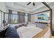 This is a beautiful bedroom with a dark four-poster bed, a mounted TV, and plenty of natural light at 9743 Amber Chestnut Way, Winter Garden, FL 34787