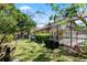 Spacious backyard featuring a screened-in pool, a grill, and lush greenery at 10116 Pointview Ct, Orlando, FL 32836