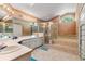 Main bathroom featuring double sinks, a walk-in shower, and a luxurious soaking tub at 10116 Pointview Ct, Orlando, FL 32836