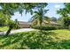 Lovely home featuring a circular driveway, lush green lawn, and mature palm trees at 10116 Pointview Ct, Orlando, FL 32836