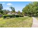 Well-maintained front yard featuring mature trees, trimmed hedges, and green lawn with sidewalk view at 10116 Pointview Ct, Orlando, FL 32836