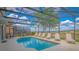 Outdoor pool with multiple chairs and view of water in background at 1040 Andalusia Loop, Davenport, FL 33837