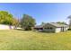 Expansive backyard with a well-manicured lawn, mature trees, and outdoor seating areas at 11139 Crooked River Ct, Clermont, FL 34711