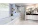 Bathroom featuring a soaking tub and a separate glass-enclosed shower adjacent to a double vanity at 11139 Crooked River Ct, Clermont, FL 34711