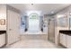 Elegant bathroom featuring a soaking tub beneath an arched window and a separate glass-enclosed shower at 11139 Crooked River Ct, Clermont, FL 34711