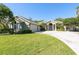 Charming home boasts a circular driveway, lush lawn, and well-maintained landscaping with mature trees at 11139 Crooked River Ct, Clermont, FL 34711
