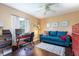 Inviting home office space with a comfortable couch, desk, and natural light from the window at 11139 Crooked River Ct, Clermont, FL 34711