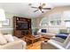 Comfortable living room with a vaulted ceiling, a large entertainment center, and hardwood floors at 11139 Crooked River Ct, Clermont, FL 34711