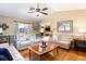 Comfortable living room showcasing neutral tones, hardwood floors, and a stylish ceiling fan at 11139 Crooked River Ct, Clermont, FL 34711