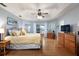 Bright main bedroom with tray ceiling, hardwood floors, and access to a private outdoor space at 11139 Crooked River Ct, Clermont, FL 34711