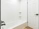 Bright, modern bathroom features sleek white tile, a bathtub, and a modern faucet at 116 E Cottesmore Cir, Longwood, FL 32779