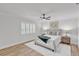 Bright bedroom featuring wood floors, ceiling fan, white walls, and natural light from a large window at 116 E Cottesmore Cir, Longwood, FL 32779