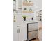 Close-up of a modern kitchen counter with white cabinets, stainless steel refrigerator drawers, and decorative shelving at 116 E Cottesmore Cir, Longwood, FL 32779