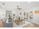 Bright living room with white walls, light wood floors, modern furniture, and French doors leading to an outdoor space at 116 E Cottesmore Cir, Longwood, FL 32779