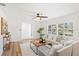 Sunlit living room showcasing hardwood floors, white walls, and large windows with plantation shutters at 116 E Cottesmore Cir, Longwood, FL 32779