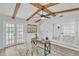 Home office with wood beams, French doors, natural light, and comfortable workspace at 116 E Cottesmore Cir, Longwood, FL 32779