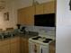 Kitchen features wood cabinets, gray countertops, and modern white appliances with a black microwave above stove at 1285 S South Beach Circle Cir, Kissimmee, FL 34746