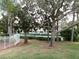 Community tennis court with mature landscaping behind a white fence offers privacy and recreation at 1285 S South Beach Circle Cir, Kissimmee, FL 34746