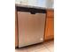 Close-up of stainless steel dishwasher, next to wooden cabinets and granite countertops at 13422 Exbury Ln, Windermere, FL 34786