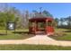 Charming red gazebo with landscaping, providing a peaceful spot to relax and enjoy the view at 13422 Exbury Ln, Windermere, FL 34786