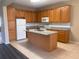 Well-equipped kitchen with granite countertops, an island, and wooden cabinetry for a functional space at 13422 Exbury Ln, Windermere, FL 34786