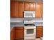 Classic kitchen featuring wooden cabinetry, white appliances, and granite countertops, offering a timeless appeal at 13422 Exbury Ln, Windermere, FL 34786