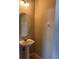 Cozy powder room featuring a pedestal sink, oval mirror, and neutral wall colors at 13422 Exbury Ln, Windermere, FL 34786