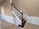Elegant staircase featuring wooden handrail and white risers complemented by beige walls and decorative wainscoting at 13422 Exbury Ln, Windermere, FL 34786