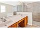 Bathroom features double sinks, wood cabinets, tiled flooring and a glass door shower at 14740 Hartford Run Dr, Orlando, FL 32828