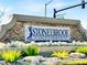 Stoneybrook: A golf community sign with stone detail, flowers, rocks, and lush green plants at 14740 Hartford Run Dr, Orlando, FL 32828
