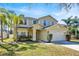 Two-story home featuring a two-car garage, a well-manicured lawn, and lush landscaping at 14740 Hartford Run Dr, Orlando, FL 32828