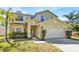 Inviting two-story home with a two-car garage, a well-maintained lawn, and a charming front entrance at 14740 Hartford Run Dr, Orlando, FL 32828