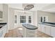 Bright eat-in kitchen with island, tile floors, bay window, and white cabinets at 14740 Hartford Run Dr, Orlando, FL 32828