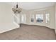 Open living area with a staircase, large windows, and neutral carpeting at 14740 Hartford Run Dr, Orlando, FL 32828