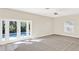 Carpeted living room with ceiling fan and glass doors leading to the pool area at 14740 Hartford Run Dr, Orlando, FL 32828