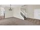 Inviting living room featuring tile flooring, carpet, and stairs leading to the upper level at 14740 Hartford Run Dr, Orlando, FL 32828