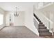 Bright living room with staircase, carpeted floors, and neutral walls at 14740 Hartford Run Dr, Orlando, FL 32828