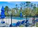Community pool surrounded by a black metal fence and sun loungers at 14740 Hartford Run Dr, Orlando, FL 32828