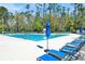 Community pool with rows of lounge chairs and blue umbrellas at 14740 Hartford Run Dr, Orlando, FL 32828