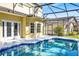 Screened pool with patio, blue tile trim, and adjacent lawn at 14740 Hartford Run Dr, Orlando, FL 32828