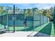 Community tennis court behind a green chainlink fence at 14740 Hartford Run Dr, Orlando, FL 32828
