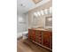 Bathroom featuring dual vessel sinks, wood cabinets, and a shower with a glass door at 1475 Kettledrum Trl, Deltona, FL 32725