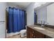 Bathroom with granite vanity, sink, faucet, toilet and bathtub with blue shower curtain at 150 E Robinson St # 1007, Orlando, FL 32801