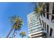 Modern high-rise building exterior with palm trees against a bright blue sky at 150 E Robinson St # 1007, Orlando, FL 32801