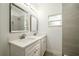 Bathroom with dual sinks, quartz counters, and a tiled shower with a glass door at 1505 25Th St, Orlando, FL 32805