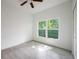This bedroom boasts tile flooring, a ceiling fan, and a window overlooking the home's lawn at 1505 25Th St, Orlando, FL 32805
