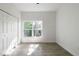 This bright bedroom features wood-look tile flooring, a window, and a closet with paneled doors at 1505 25Th St, Orlando, FL 32805