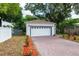 A detached garage with a new white door, brick-paved driveway, and manicured landscaping at 1505 25Th St, Orlando, FL 32805